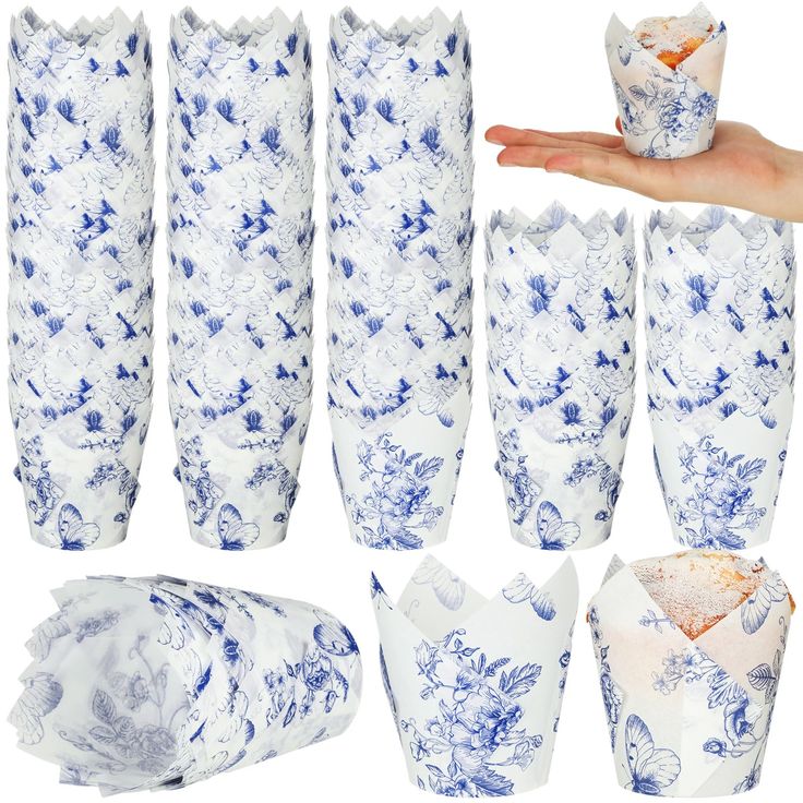 blue and white vases are being held by someone's hand, with paper wrapped around them