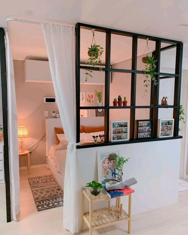 a living room filled with lots of furniture next to a white wall covered in plants