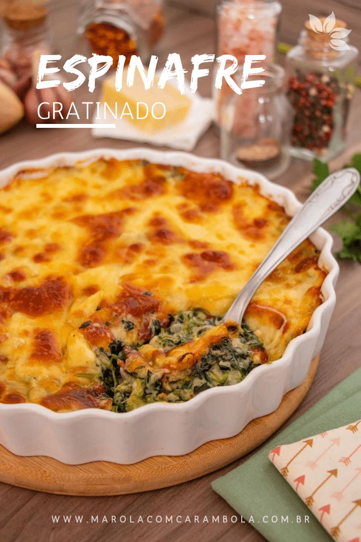 a casserole dish with cheese and spinach in it on a wooden table