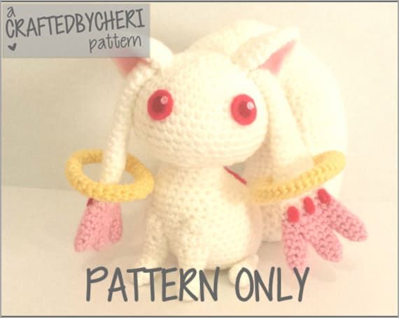 a crocheted white stuffed animal with red eyes and yellow ribbon around its neck