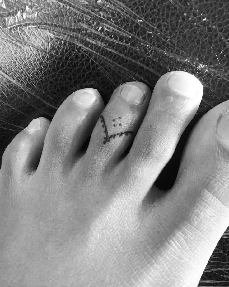 a person's foot with a small tattoo on it