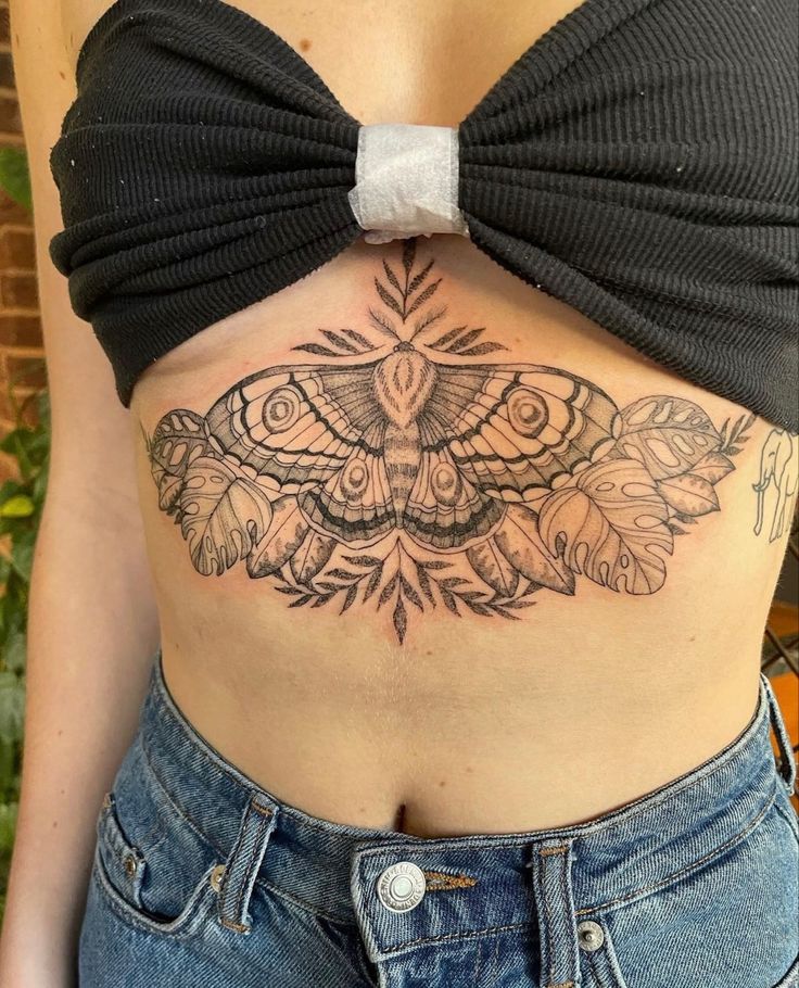 a woman with a butterfly tattoo on her stomach