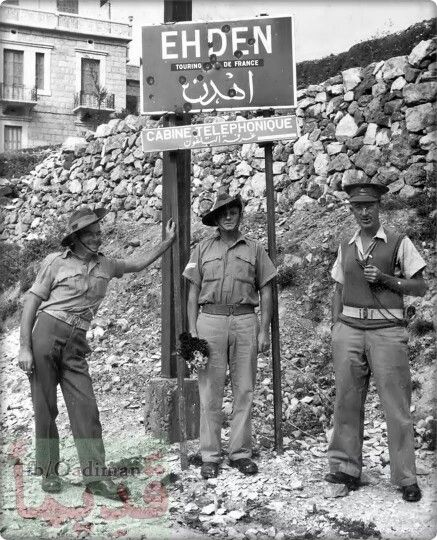 two men standing next to each other near a sign