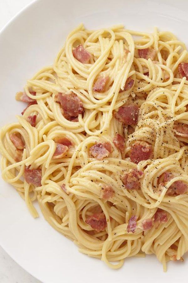 pasta with bacon and parmesan cheese on a white plate