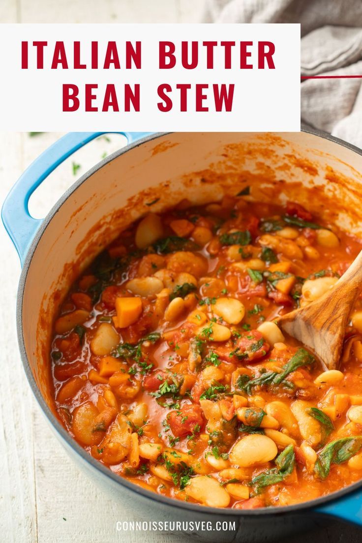 italian butter bean stew in a blue pot with a wooden spoon