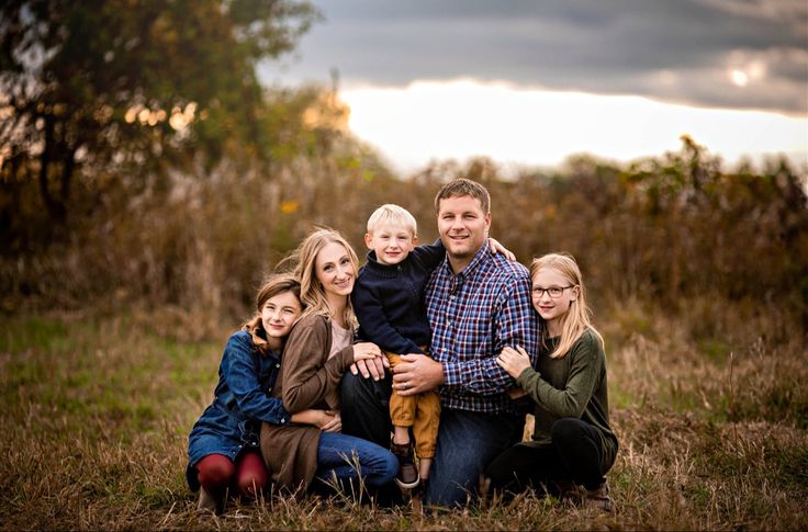 a family poses for a photo in a field