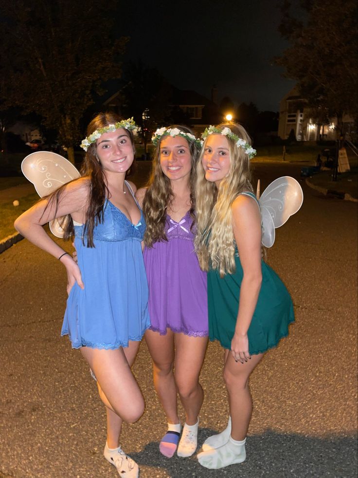 three girls dressed in fairy costumes posing for the camera