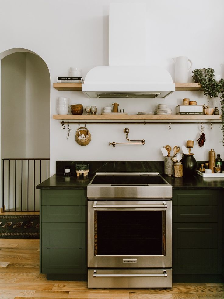 a stove top oven sitting inside of a kitchen next to a counter with pots and pans on it