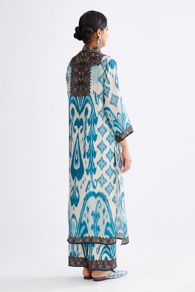 Aqua silk long kurta with band collar, front buttoned placket and all-over abstract prints.
Components: 1
Pattern: Printed
Type Of Work: Abstract
Neckline: Band Collar
Sleeve Type: Three Quarter
Fabric: Silk
Color: Blue
Other Details: 
Beaded sleeve hem
Closure: Front button placket
Note: Pant worn by the model is not for sale
Occasion: Puja - Aza Fashions Printed Silk Long Sleeve Kurta, Silk Long Sleeve Printed Kurta, Bohemian Straight Kurta In Patterned Color, Bohemian Ikat Print Patterned Kurta, Silk Ikat Print Straight Kurta, Silk Straight Kurta With Ikat Print, Bohemian Straight Kurta With Batik Print, Bohemian Patterned Kurta With Printed Motifs, Bohemian Silk Kurta For Eid