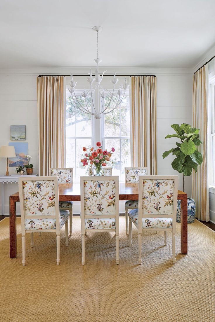 a dining room table with four chairs and a chandelier