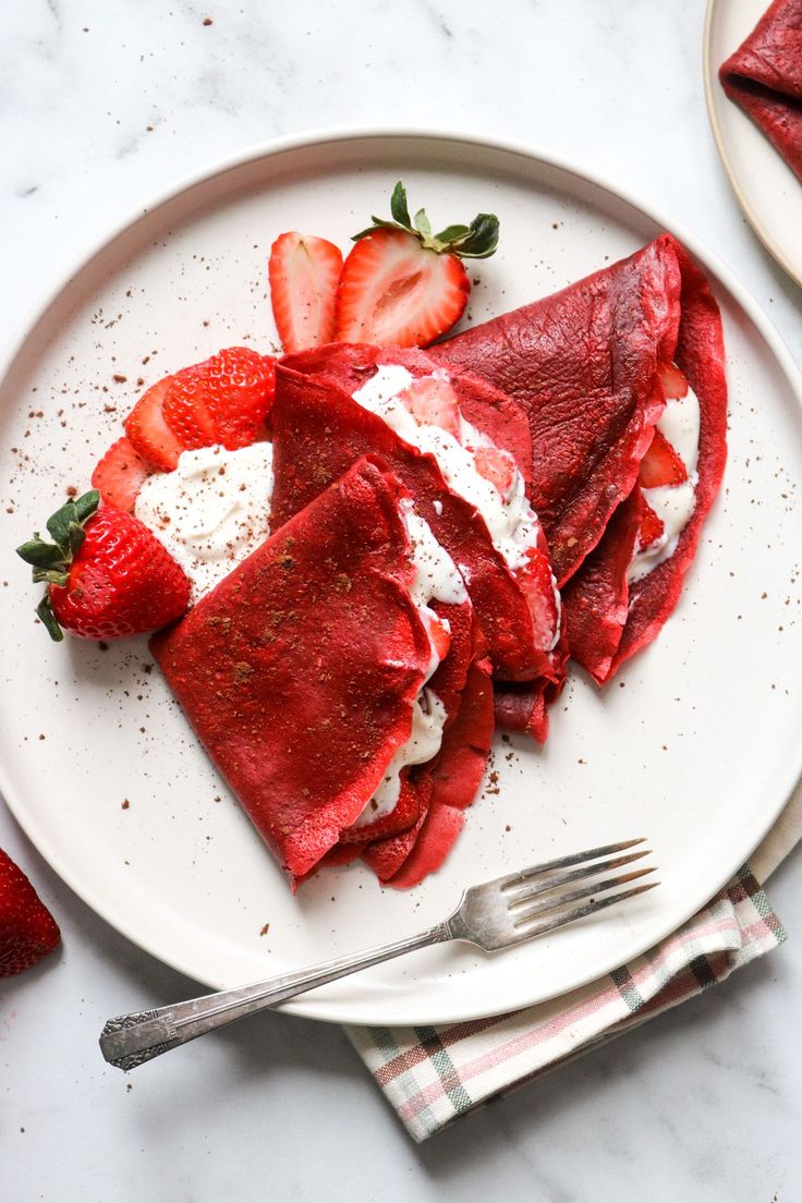 red velvet crepes with cream cheese yogurt filling on a white plate