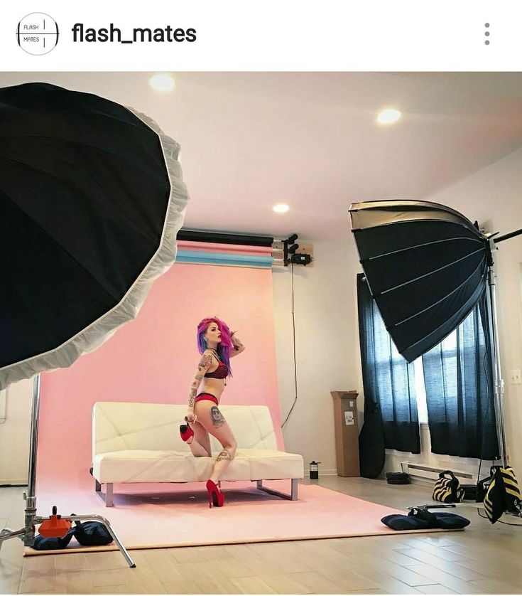 a woman is dancing on a pink rug in front of a white couch and black drapes