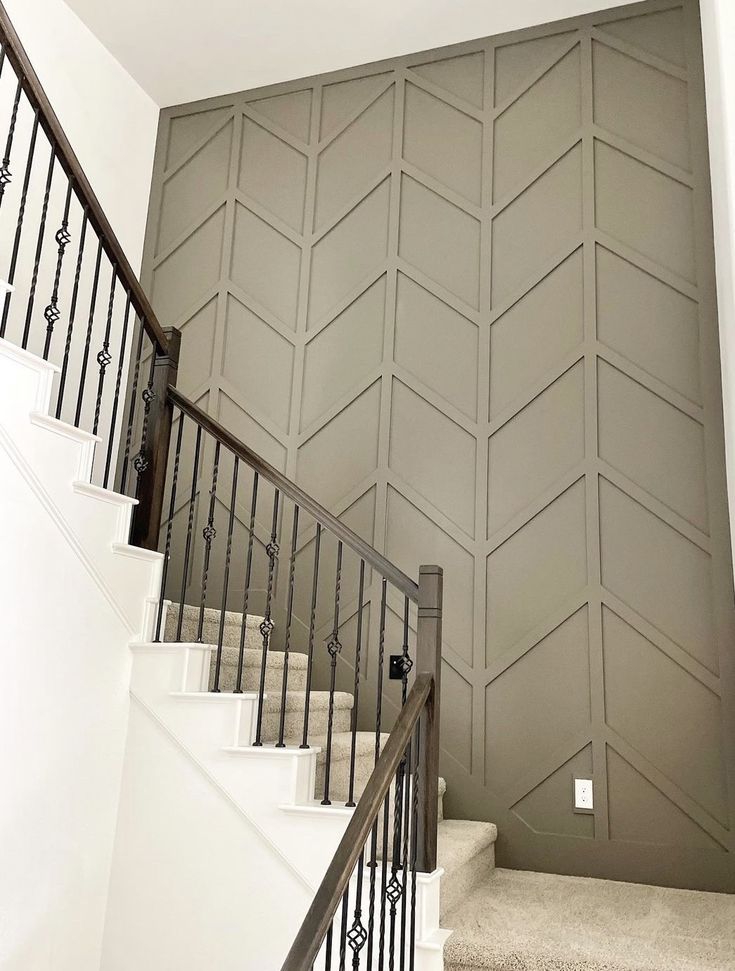 a stair case next to a set of stairs in a room with gray walls and white carpet