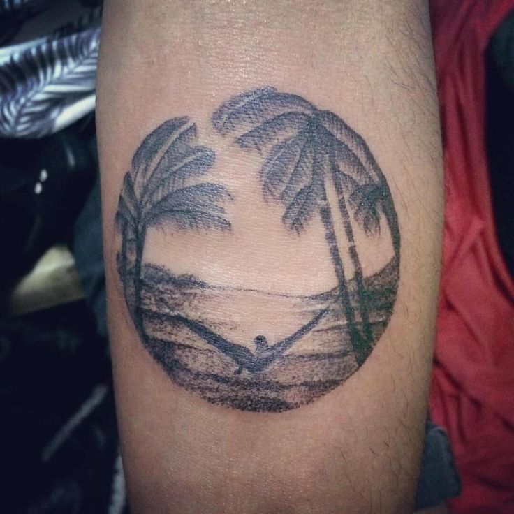 a man's arm with a palm tree tattoo on the left side of his arm