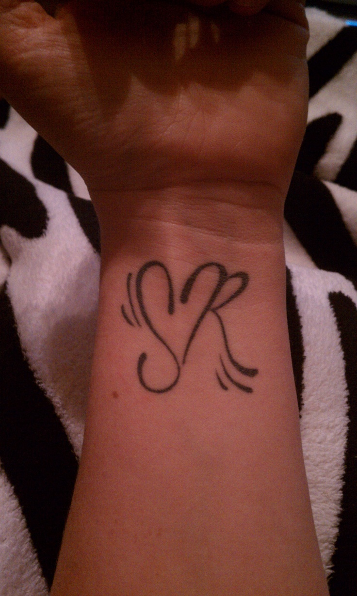 a woman's wrist with a small tattoo design on the left side of her arm