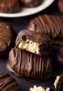 chocolate covered desserts on a table with one cut in half