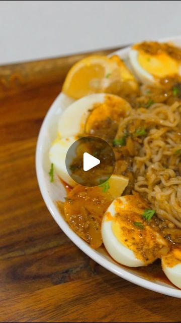 a bowl filled with rice and eggs on top of a wooden table next to an orange slice