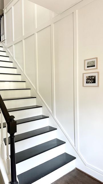 there is a black and white stair case on the wall next to the banister