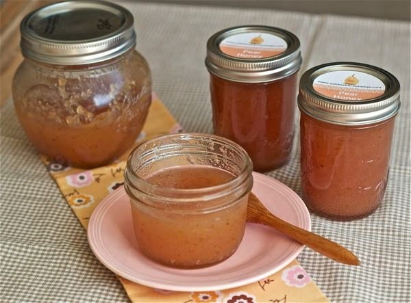 three jars of jam sitting on top of a table next to a plate and spoon