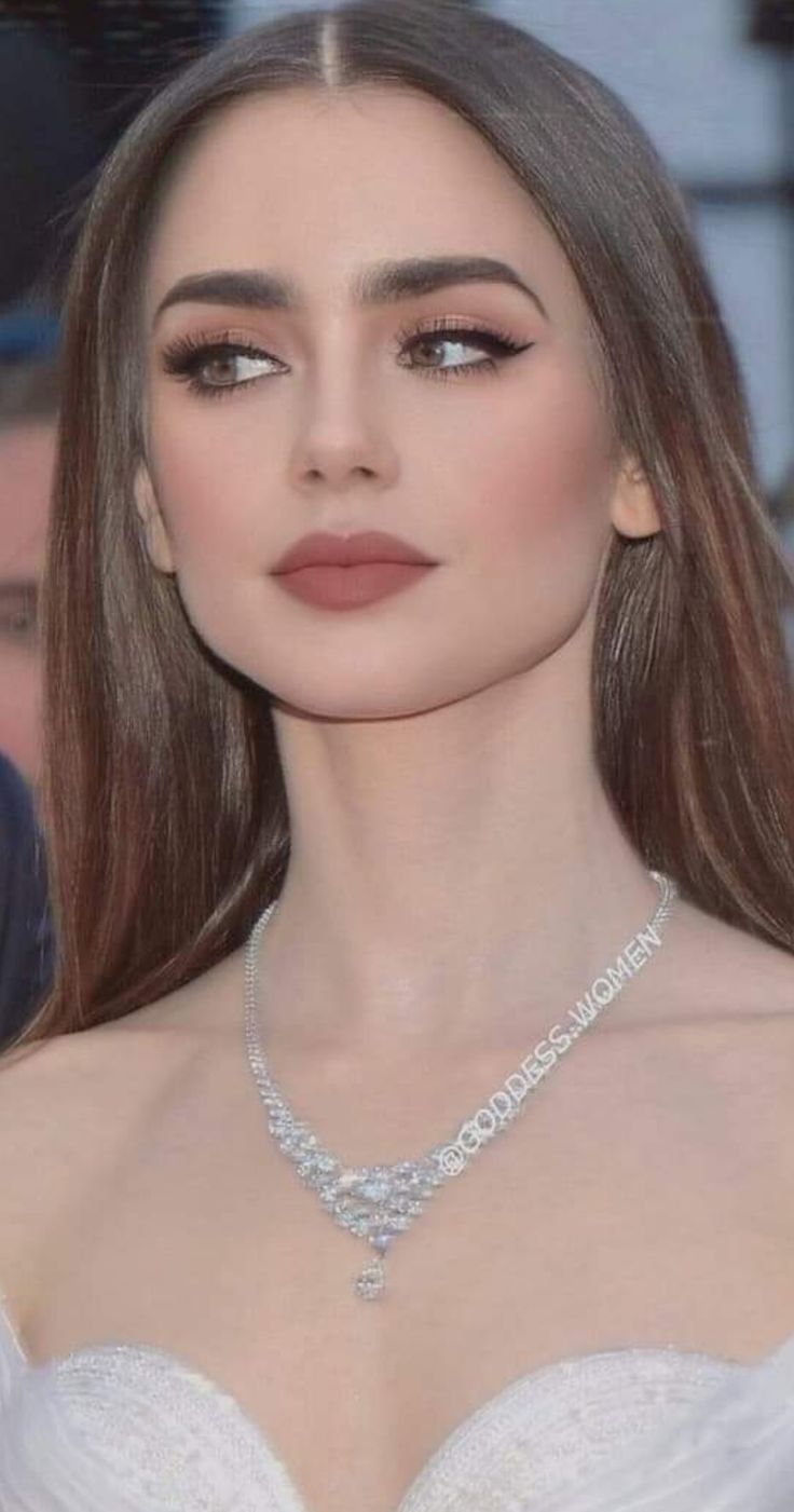 a woman with long hair wearing a white dress and diamond choker on her neck