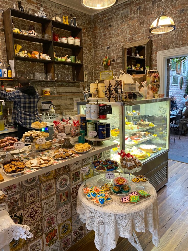 a bakery filled with lots of pastries and desserts on top of wooden tables