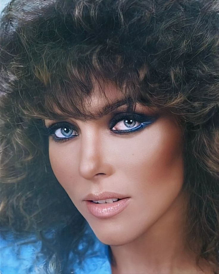 a woman with curly hair and blue eyes