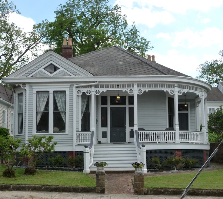 a white victorian style house with porches and windows