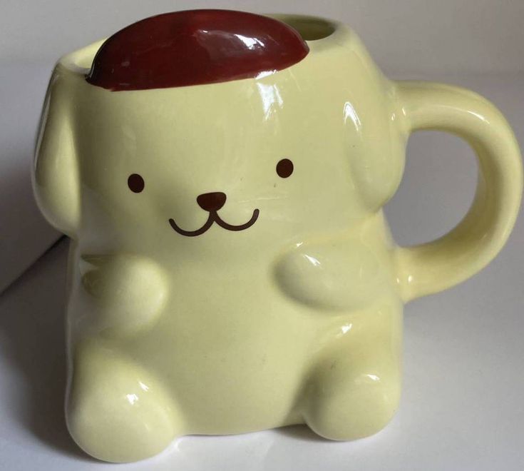 a ceramic mug with a dog's face painted on the front and sides, sitting on a white surface