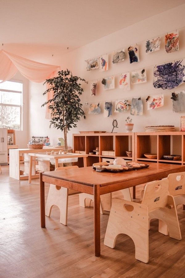 a room with wooden tables and chairs in front of a wall full of pictures on the walls