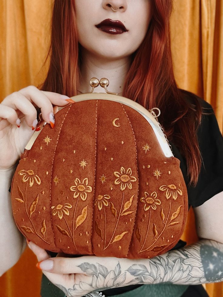 This stylish pumpkin inspired purse features a beautiful embroidery pattern of stars, moons, and flowers. Features a vintage style kiss lock clasp. Great for witchy fashion. #whimsigoth #witchyfashion #alternativefashion #purses #vintagefashion #embroidery #cottagecore Kiss Clasp Purse, Kiss Clasp Purse Pattern, Witchy Sewing, Cottagecore Goth Aesthetic, Little Embroidery Ideas, Pumpkin Accessories, Cottagecore Purse, Cottagecore Pumpkin, Witchy Embroidery