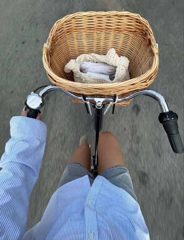 a person riding a bike with a basket on the back