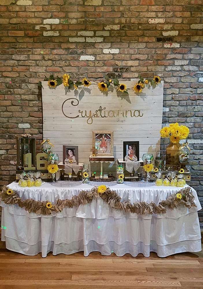 a table topped with yellow flowers next to a brick wall