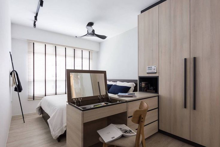 a bedroom with wooden furniture and white walls