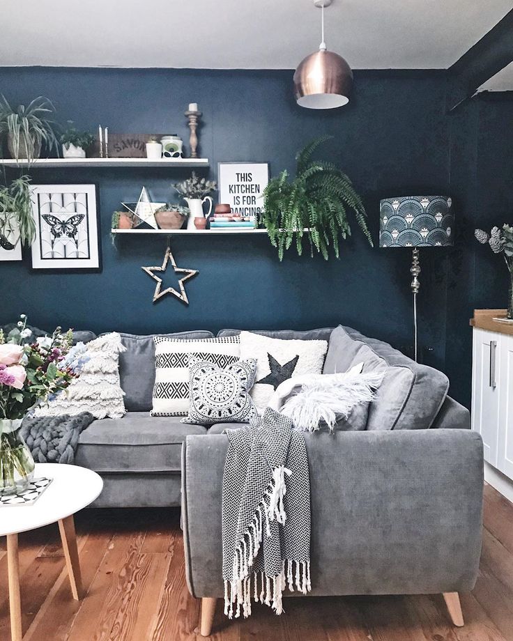 a living room filled with furniture and lots of plants on top of it's shelves