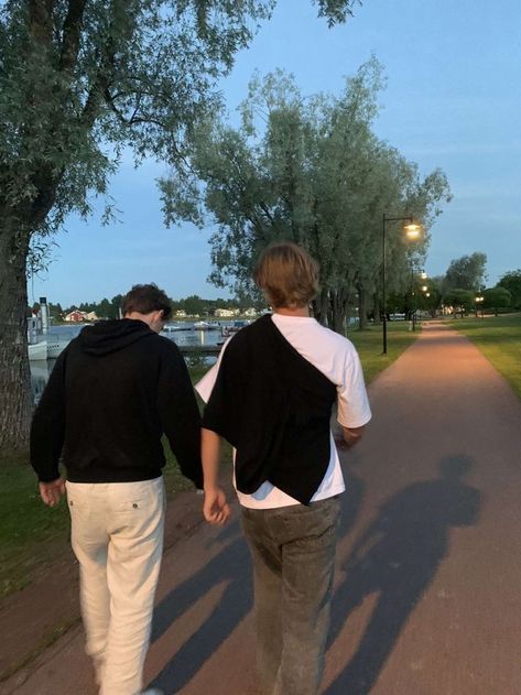 two people walking down a path holding hands