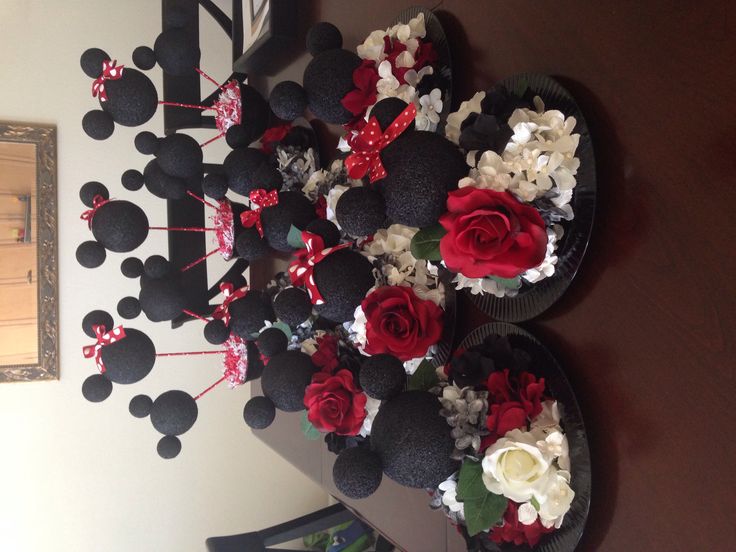 a table topped with mickey mouse cupcakes and flowers