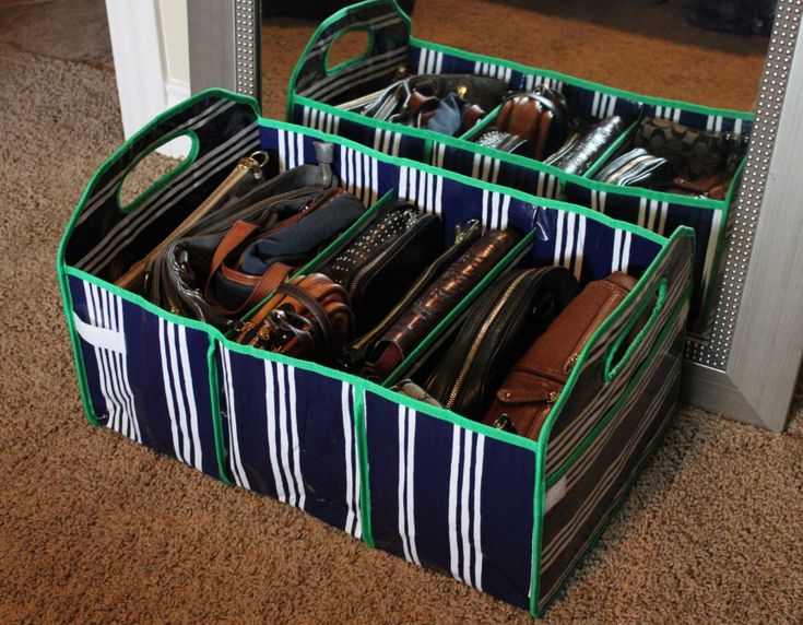 three storage bins filled with different types of purses and shoes in front of a mirror