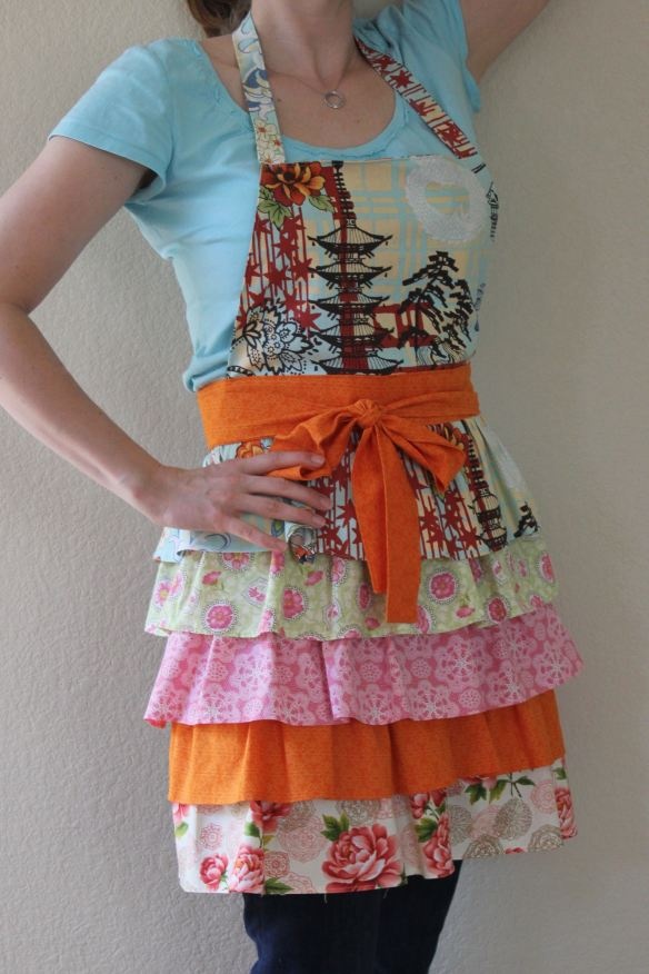 a woman is wearing an apron and posing for the camera