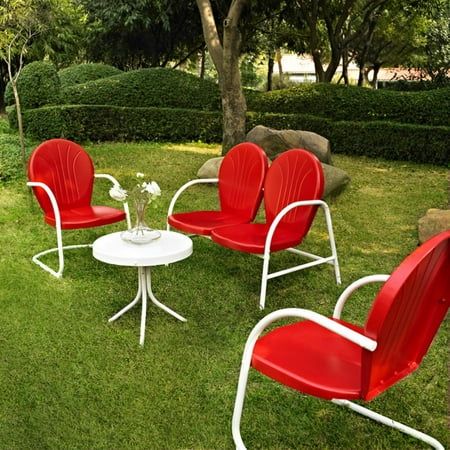 four red chairs and a white table in the grass