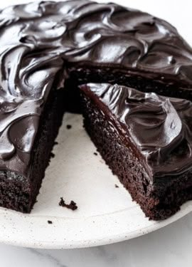 a chocolate cake on a plate with one slice cut out