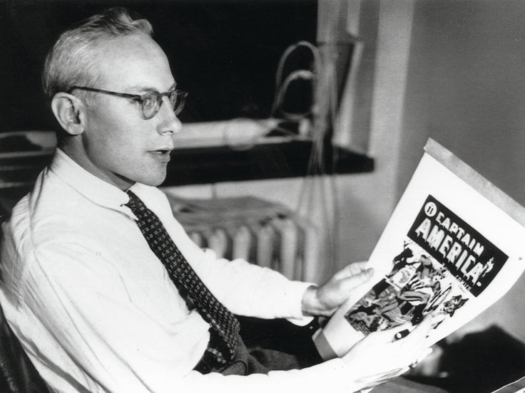 a man sitting in a chair reading a magazine