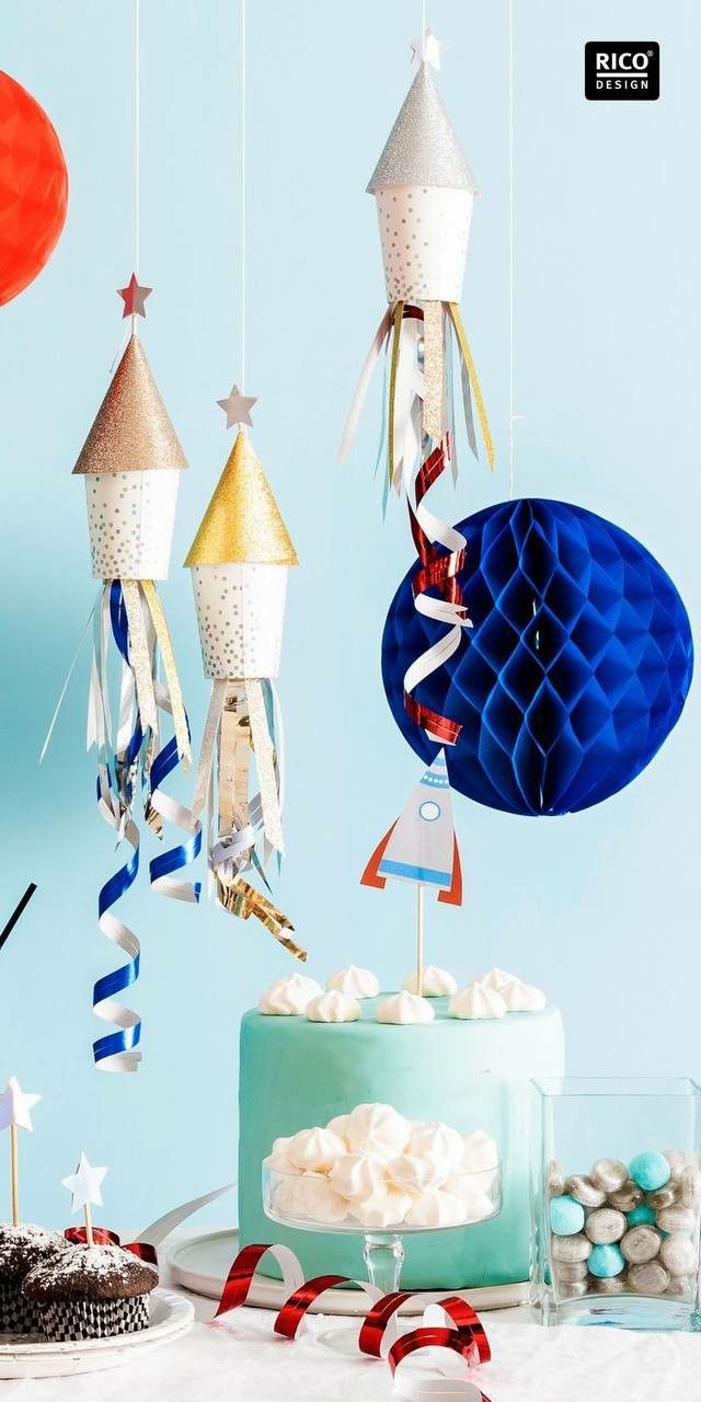 a cake with decorations hanging from it on a table next to other desserts and candies