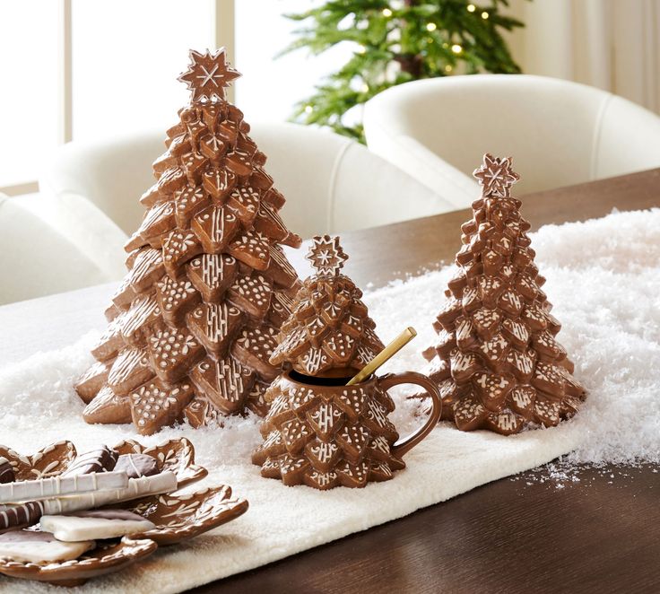 three wooden christmas trees sitting on top of a white rug next to a dining room table