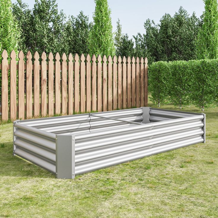 a large metal container sitting on top of a lush green field next to a wooden fence