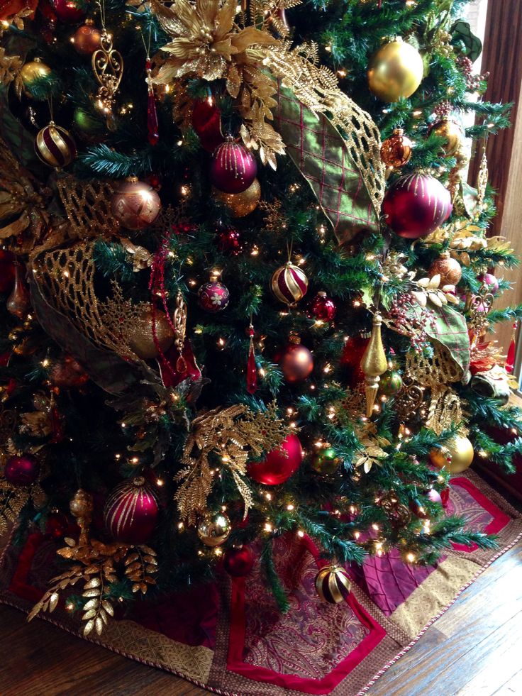 a christmas tree decorated with gold, red and green ornaments