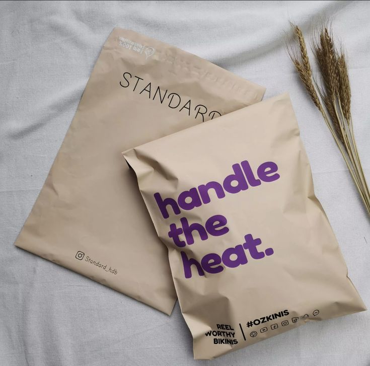 two bags of food sitting on top of a bed next to some dried wheat stalks