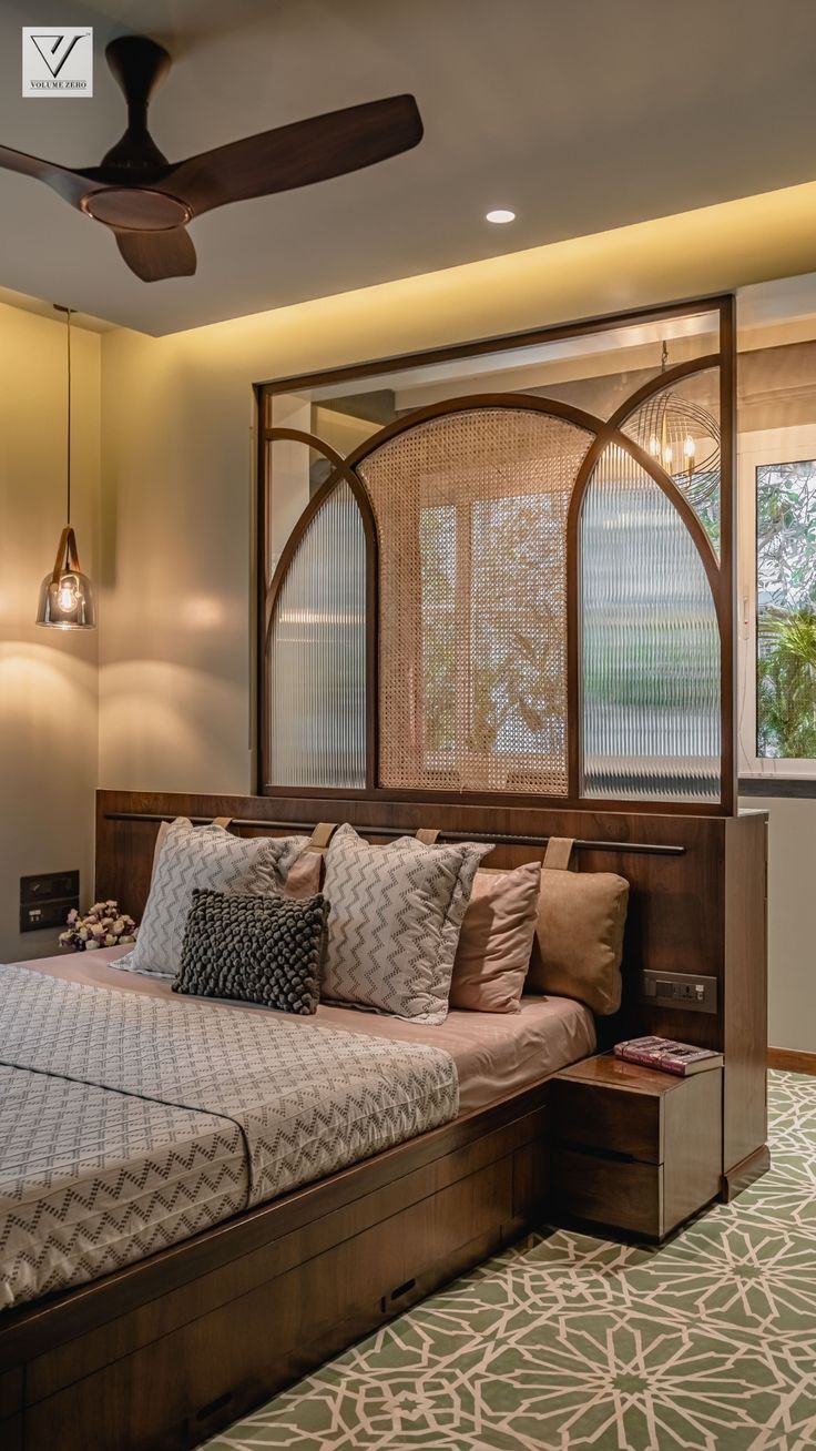 a bed sitting under a ceiling fan in a bedroom next to a wall mounted air conditioner