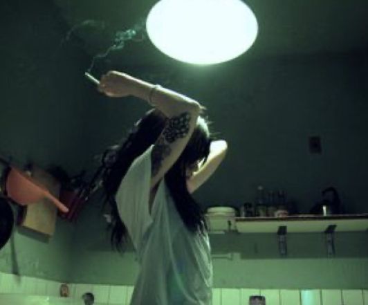 a woman standing in a bathroom holding a surfboard above her head and looking up at the ceiling