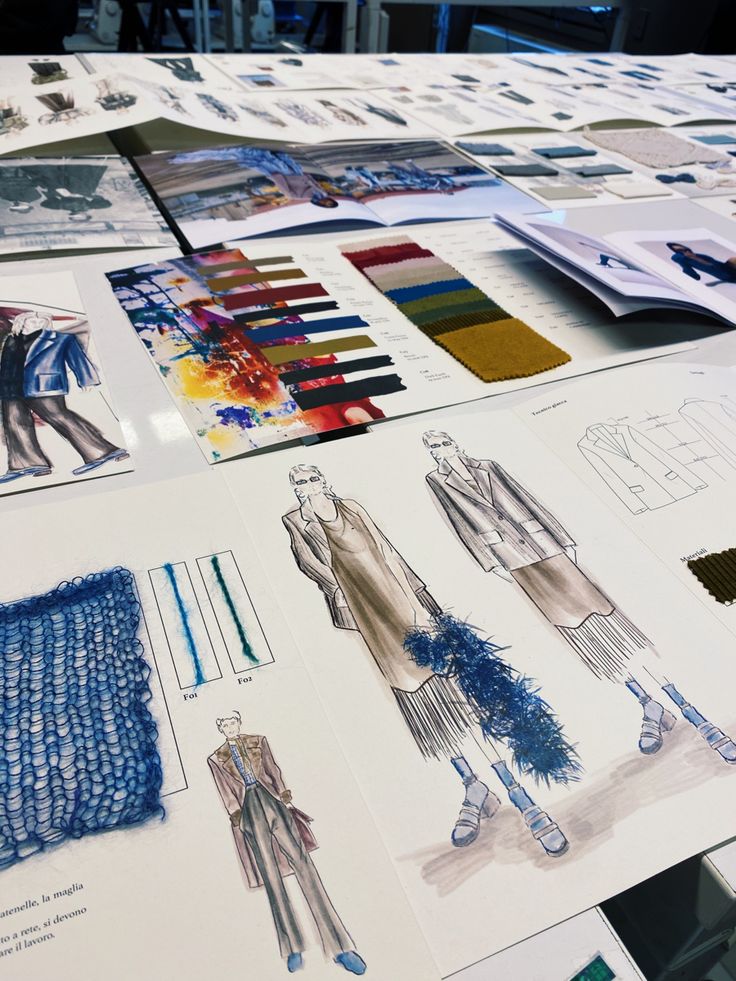 many different designs are displayed on a table with blue and white papers in the background