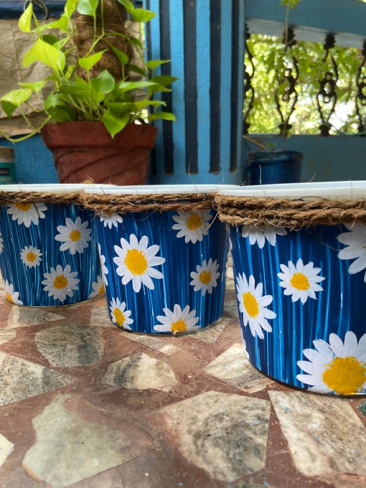 three blue and white flower pots sitting on top of a table